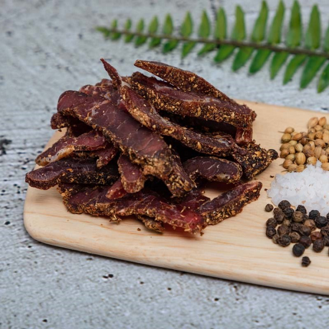 Bilpo Biltong on a cutting board with spices