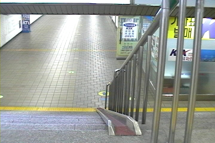 지하도로 내려가는 계단의 모습. 입간판과 문, 벽 등에 '기차표 발매', 'KTX' 등이 써있다.