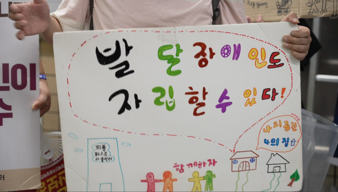 피플퍼스트 활동가가 손으로 만든 피켓. "발달장애인도 자립할 수 있다" "나의 공간 나의 집" "함께하자"라는 문구가 쓰여있다.