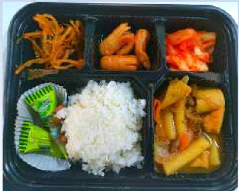 밥과 김치, 소시지와 여러 반찬으로 구성된 한식 점심 도시락