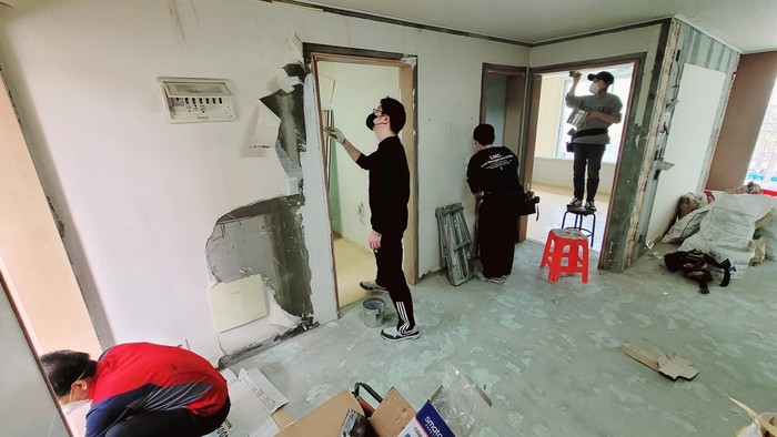 현장에서 문틀과 벽에 필름을 시공하는 교육 장면