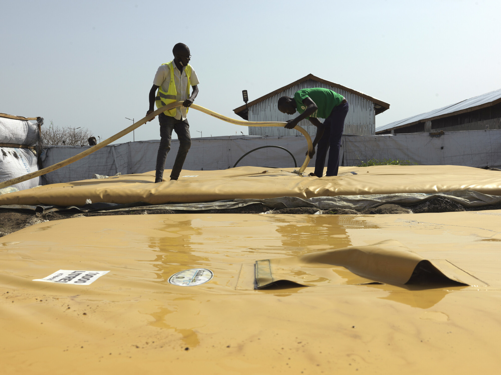 <span class="Caption_font" style="font-size:14px; color:#545454;">물탱크를 설치하고 있는 옥스팜 직원들. © Peter Caton/Oxfam</span>