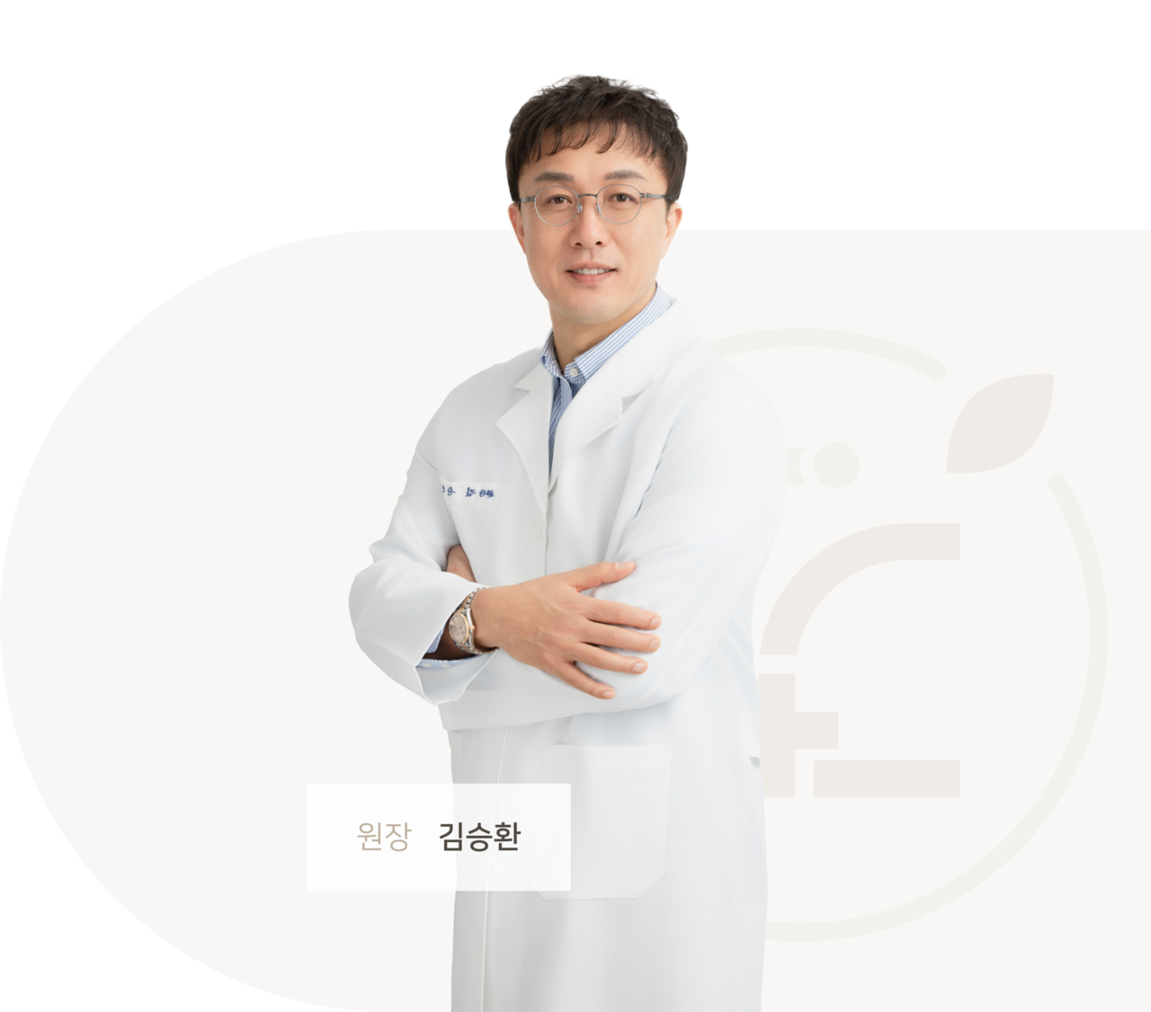짧은 머리에 안경을 쓰고 흰색 의사 가운을 입고 있는 김승환 원장님이 팔짱을 낀 채로 정면을 응시하고 있다.