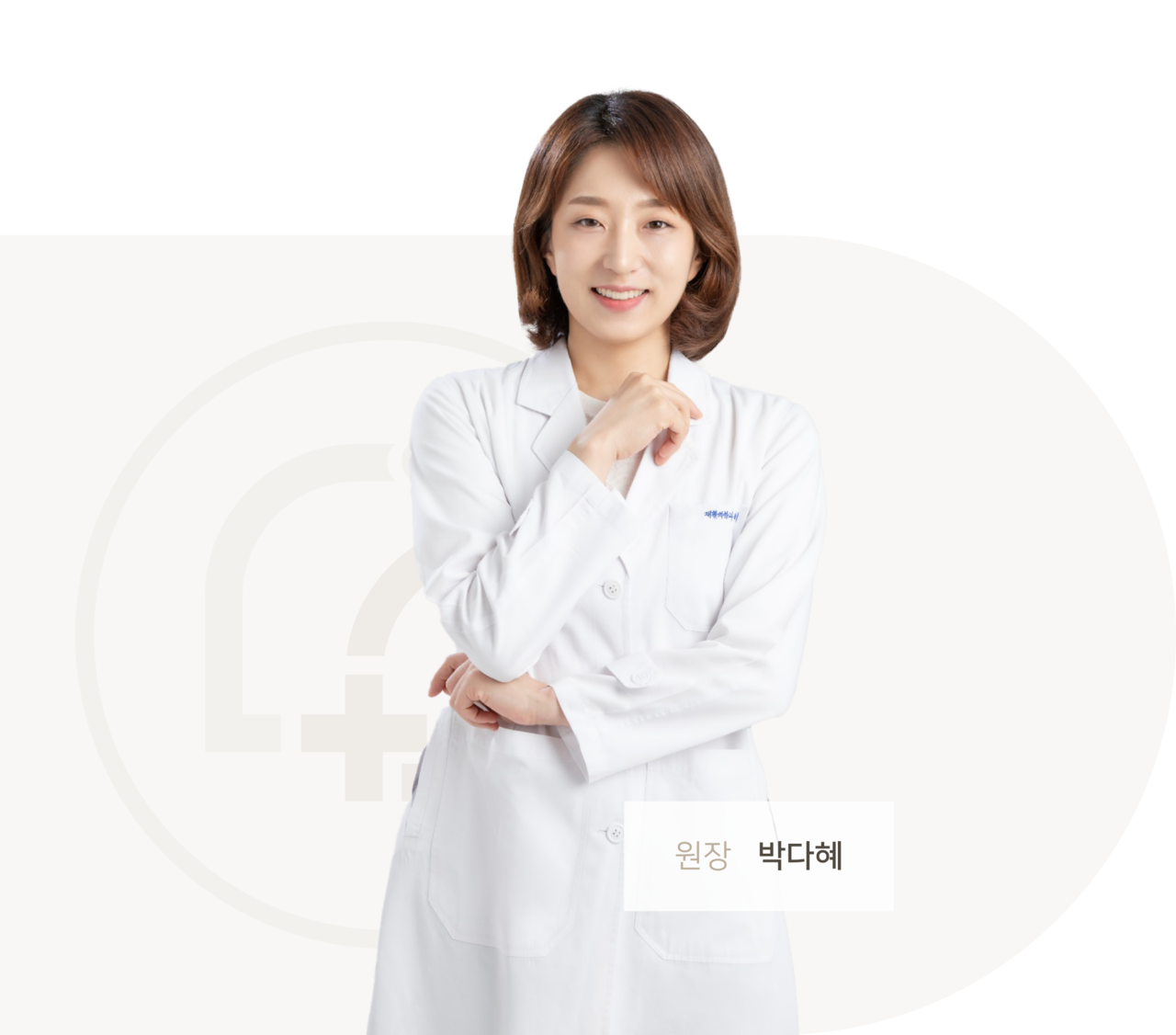 밝은 갈색 단발 머리에 흰색 의사 가운을 입고 있는 박다혜 원장님이 정면을 응시하고 있다.