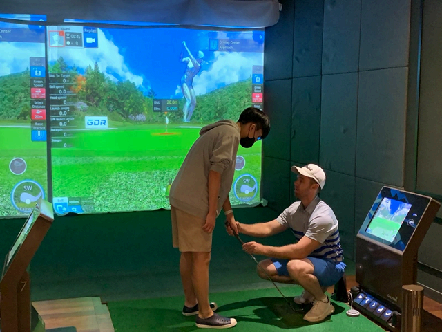 실내 골프 연습장에서 지도받는 학생
