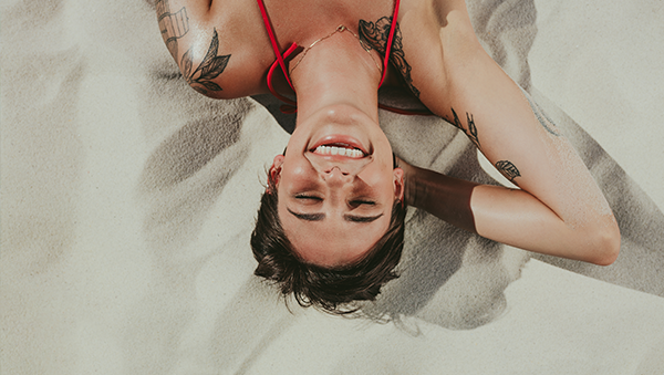 모래 위에 누워있는 여성의 모습
