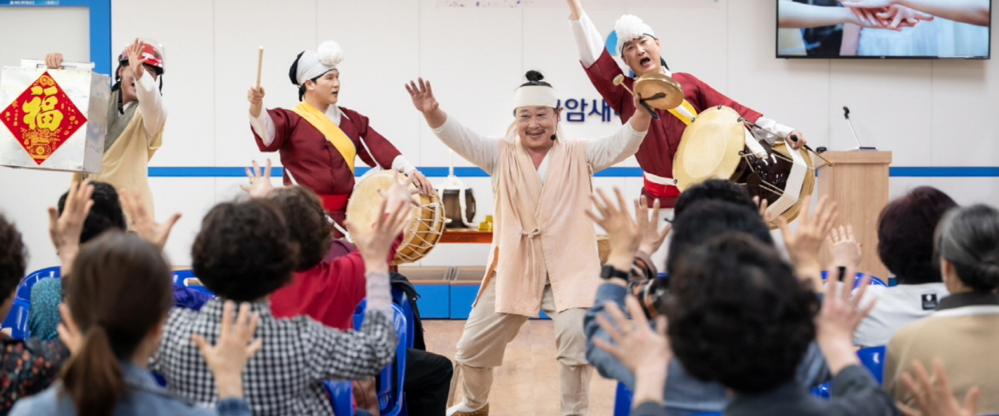 복이팡팡 공연에서 배우와 어르신 관객들이 함께 손을 들어 참여하며 신명나는 시간을 보내는 모습