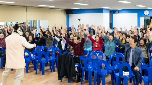 복이팡팡 공연에서 어르신 관객들이 모두 손을 들고 즐겁게 참여하는 모습
