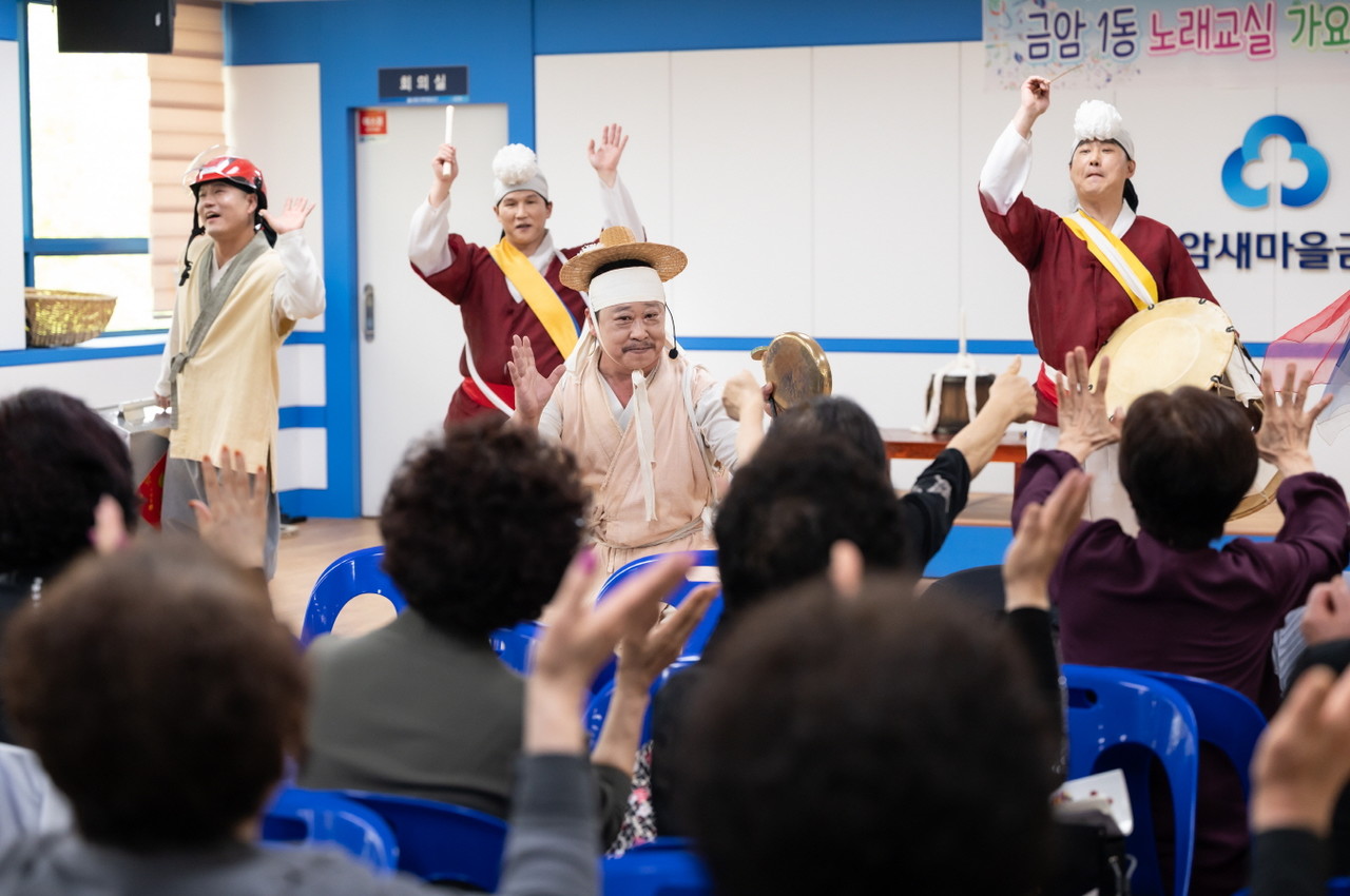 공연 중 장단에 맞춰 손을 들고 즐겁게 참여하는 어르신들과 복이팡팡 출연진