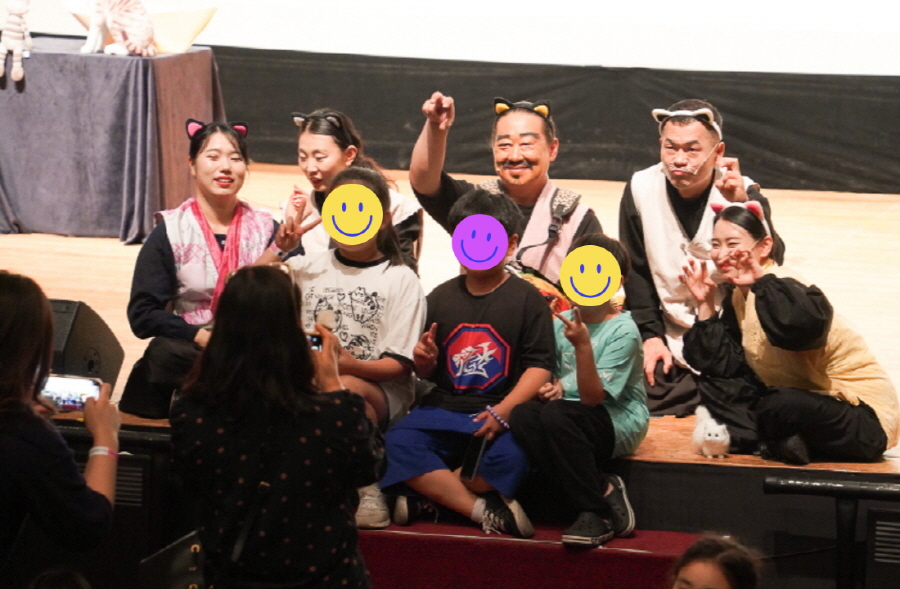 2025년 6월 17일 부안교육문화회관 공연 <나는 고양이로소이다> 종료 후, 출연진과 어린이 관객들이 무대 앞에서 함께 기념촬영을 하며 즐겁게 포즈를 취하는 모습