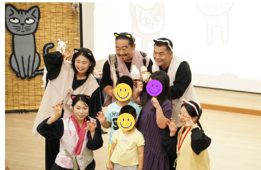 순천 기적의 도서관 공연 ‘나는 고양이로소이다’가 끝난 뒤, 고양이 분장을 한 배우들이 초등학생, 유치원아이로 구성된 가족들과 함께 무대에서 단체 사진을 찍고 있다."