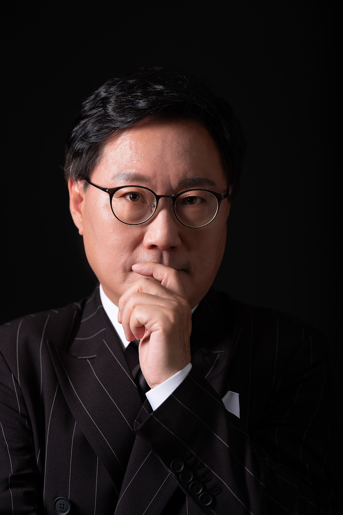 프로필사진 중년남성의 카리스마 있는 중후한 표정의 프로필사진 강한 조명이 인상적이다