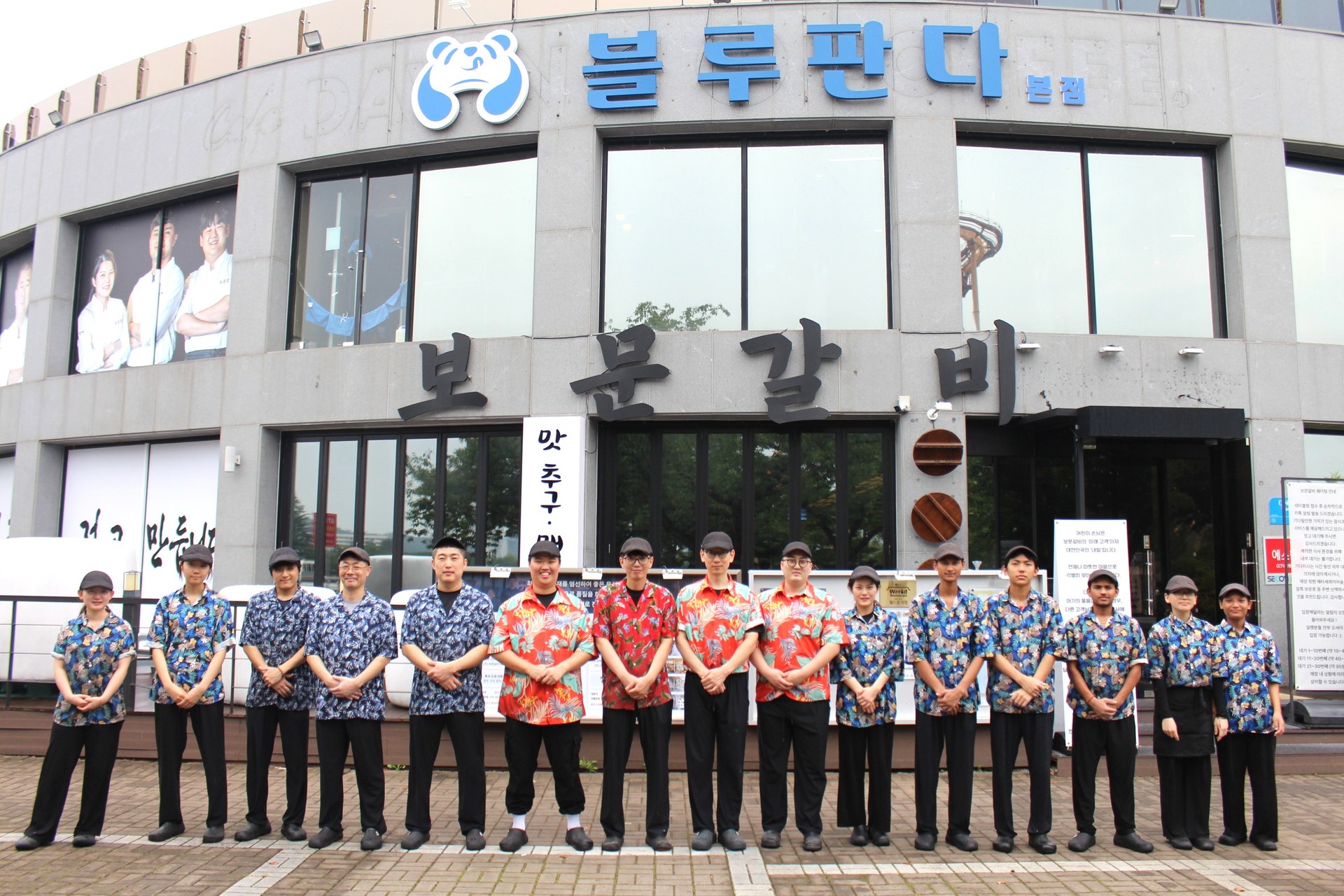 파란 유니폼을 입은 보문갈비 직원들이 매장 외관 앞에 선 단체 사진