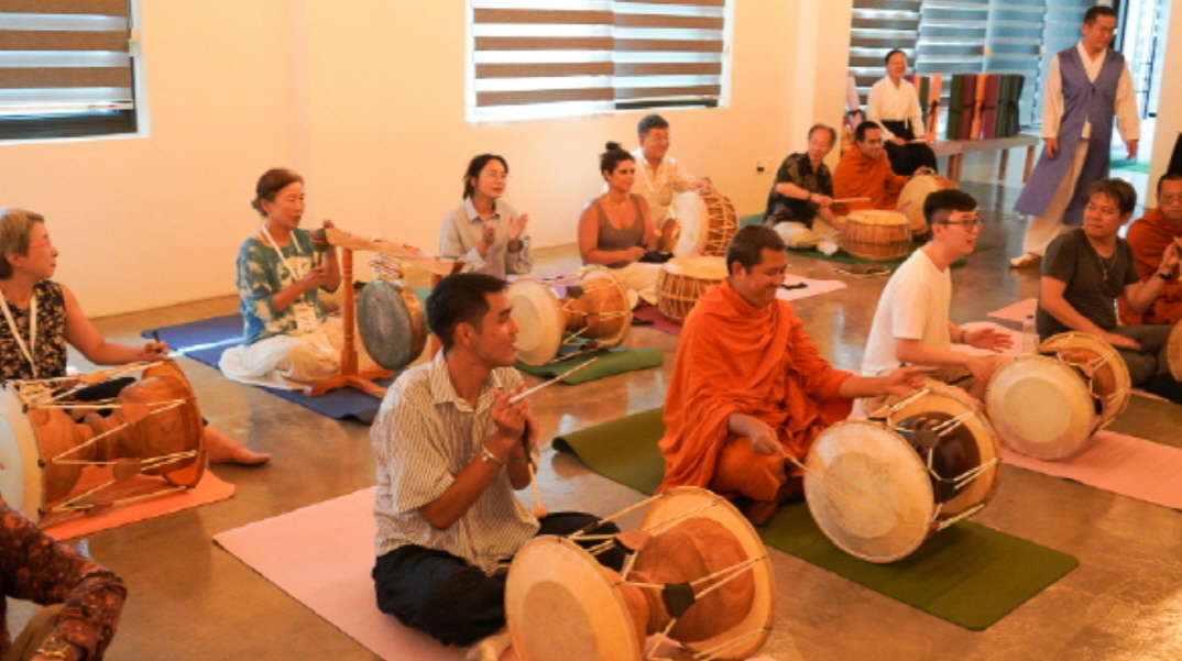 장구, 꽹과리 등 전통 악기를 연주하며 사물놀이를 체험 중인 다양한 국적의 세계 종교인 참가자들