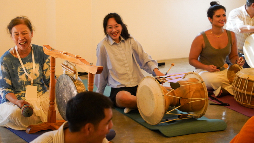 전주 한옥마을 전통 공연 체험 프로그램 한바탕 얼쑤에서 참가자들이 장구와 징을 연주하며 즐겁게 체험하는 모습 | Participants enjoying the traditional Korean performance experience 'Hanbatang Eolssu' in Jeonju Hanok Village, playing janggu and jing together