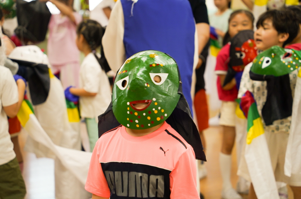 초등학교 K-POP 탈춤체험 – 저학년 어린이가 초록색 전통 탈을 쓰고 참여하는 모습