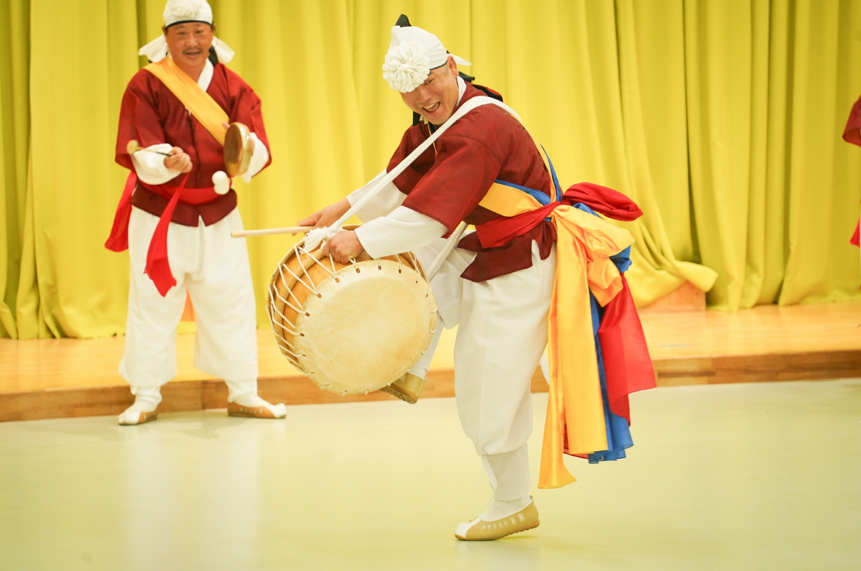 전주아름유치원에서 열린 유치원 공연 ‘풍물마당놀이 해피’ 중, 전통 의상을 입은 연희자가 북춤을 추며  웃음을 짓고 있는 모습