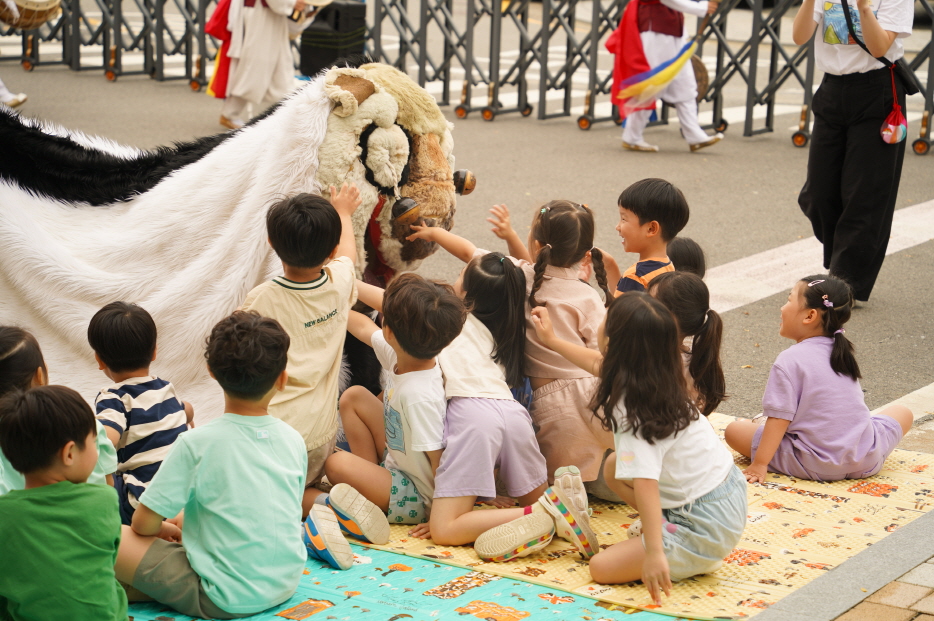 서산예천새뜰유치원 공연에서 아이들이 강아지 탈을 쓴 해피를 쓰다듬으며 즐겁게 교감하는 모습, 유치원공연  풍물마당놀이 해피