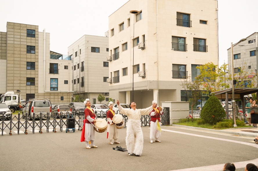서산예천새뜰유치원 공연에서 공연단이 5m높이로 버나놀이를 하며 두 팔을 벌리고 관객과 인사하며 풍물패가 북을 연주하는 모습, 전통 공연 풍물마당놀이 해피