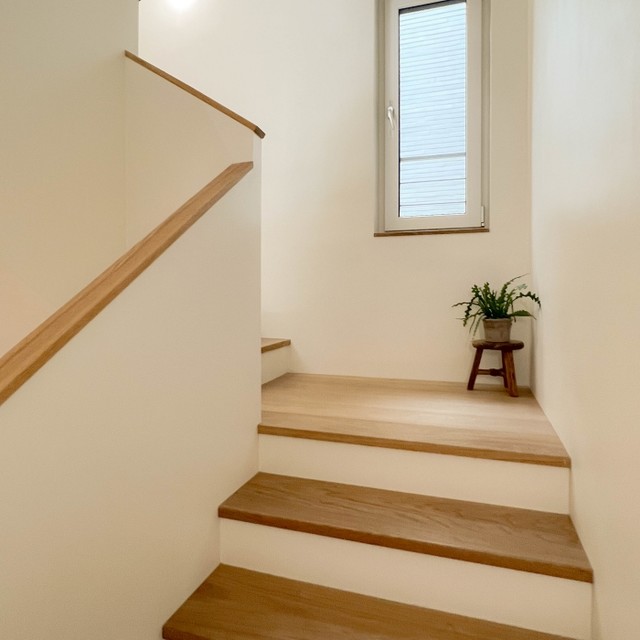 자연광과 조화를 이룬 슬림 원목 손스침 계단 디자인