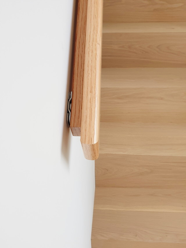 계단 벽면에 설치된 h형 원목 손스침 - 깔끔한 고정과 미려한 마감