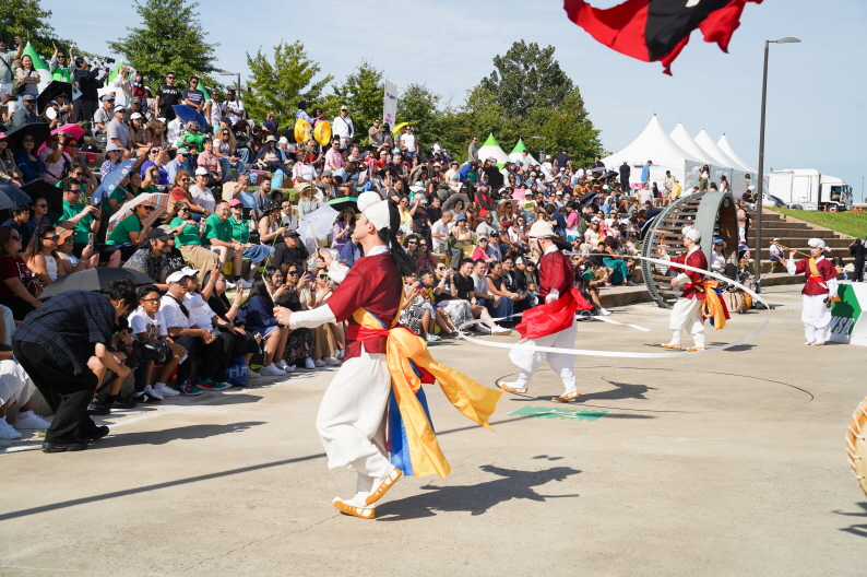 여의도 한강공원 WSB K-DAY 국제행사에서 합굿마을 전통공연단이 상모돌리기와 기접놀이 공연을 펼치며 외국인 관객들이 함께 즐기는 모습