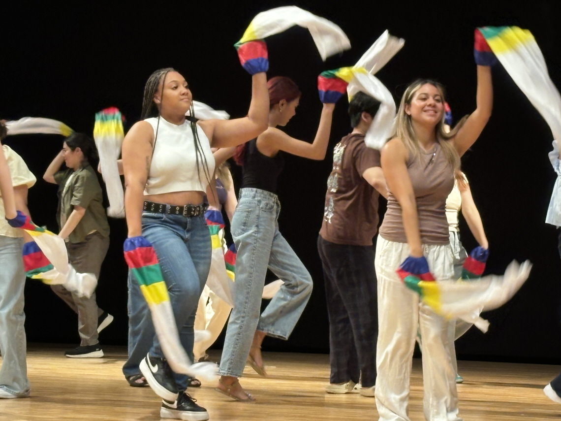 국인 참가자들이 한국 전통 문화체험 프로그램에서 오방색 천을 흔들며 무대 위에서 신나게 춤추는 모습