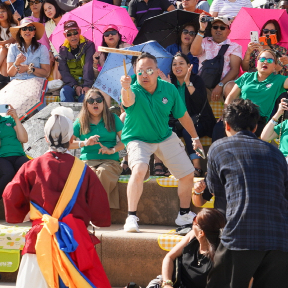 WSB K-DAY 여의도 한강공원 국제행사에서 외국인 참가자가 합굿마을 연희단과 함께 접시돌리기 체험에 참여하며 즐거워하는 모습