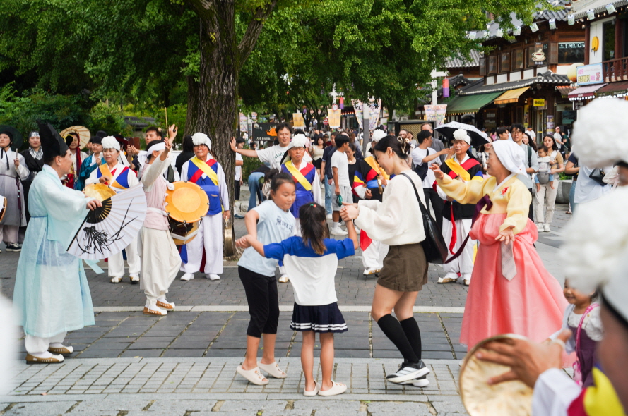 한옥마을 전통연희 퍼레이드에 참여한 가족들이 출연자들과 어울려 춤추는 모습