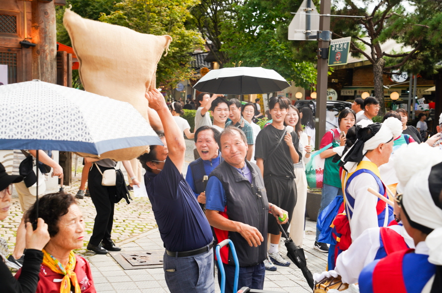 전주한옥마을 전통연희 퍼레이드, 가마니 던지기 대회에 참여하여 공중에 날아오는 가마니를 받으며 즐거워 하는 관객들 모습