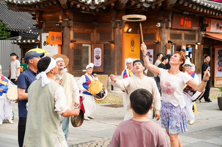 전주한옥마을 전통연희 퍼레이드, 외국인 관광객이 버나던지기 대회에 참여하여 버나를 높이 던지는 장면