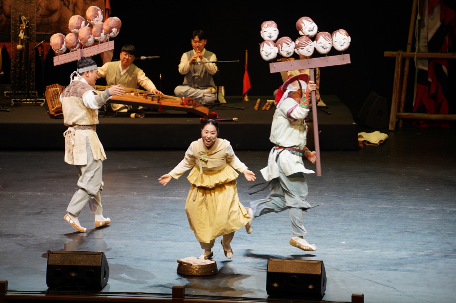 마당놀이 용을쫓는사냥꾼 공연에서 전통 소품을 활용해 배우들이 유쾌하게 뛰어다니며 관객의 웃음을 자아내는 장면