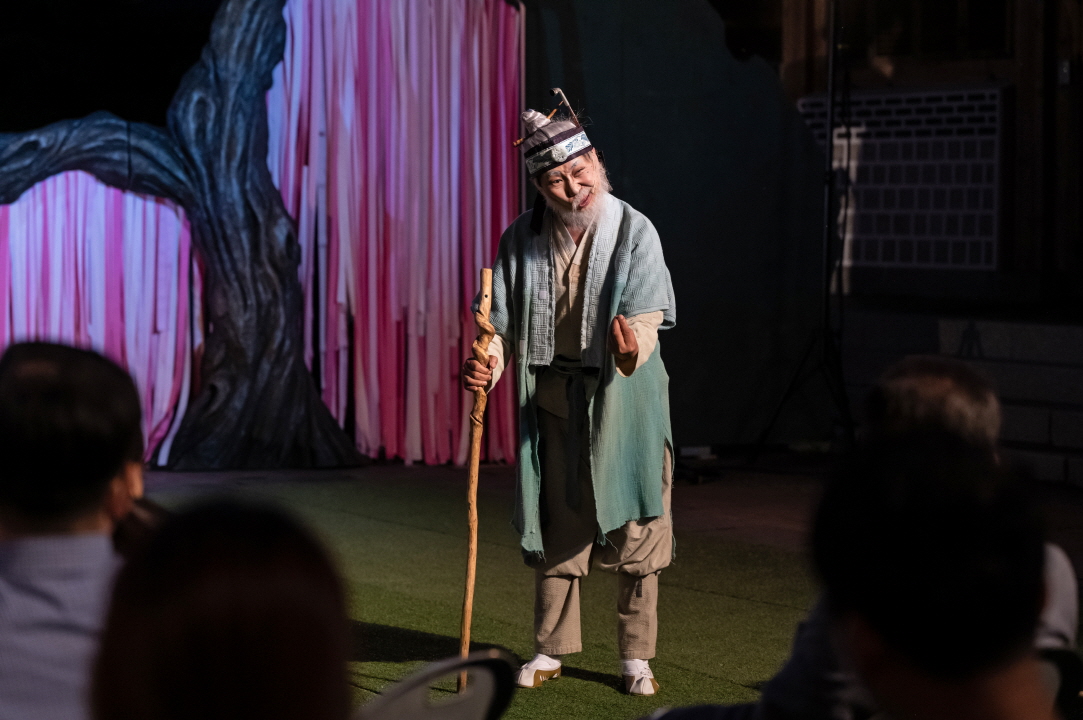 마당놀이 용을쫓는사냥꾼 공연에서 마을 이장이 주막 주모들과 함께 어수룩한 사냥꾼들에게 바가지를 씌우려 코믹하게 모의하는 장면