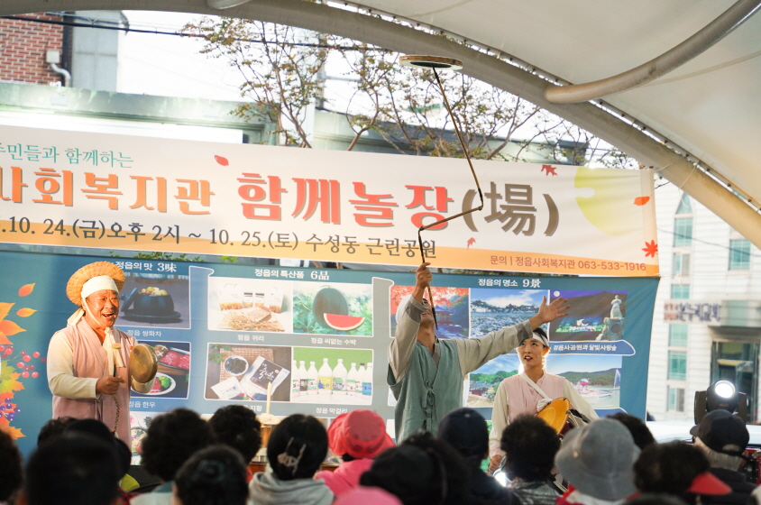 정읍사회복지관 함께놀장 행사에서 합굿마을 연희단이 복이팡팡 공연 중 버나돌리기 묘기를 선보이며 관객과 어우러지는 장면