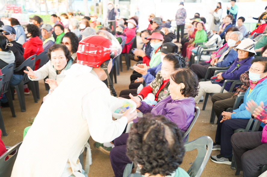 복이팡팡 공연 중 합굿마을 연희단 배우가 관객석 어르신들과 선물을 나누며 소통하는 장면