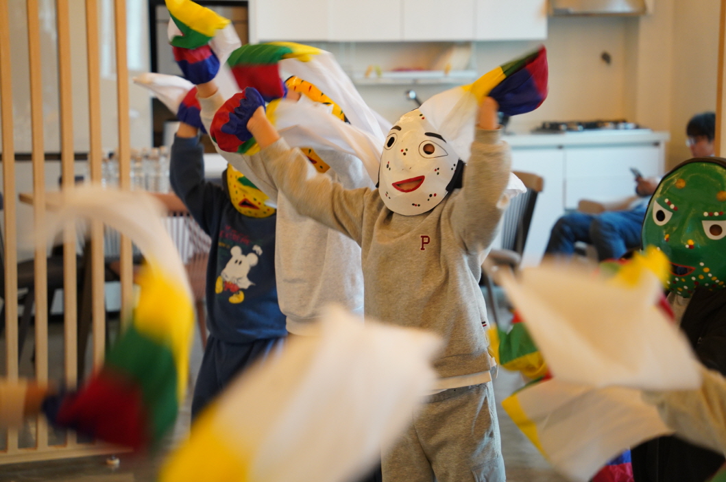 전주한옥마을 승암어울마당에서 전통 탈을 쓴 초등학생들이 오색 수건을 흔들며 신나게 춤추는 한바탕 얼쑤 전통공연체험 장면