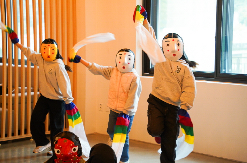 전주한옥마을에서 전통 탈을 쓴 초등학생들이 오색 수건을 흔들며 탈춤을 추는 한바탕 얼쑤 체험 장면