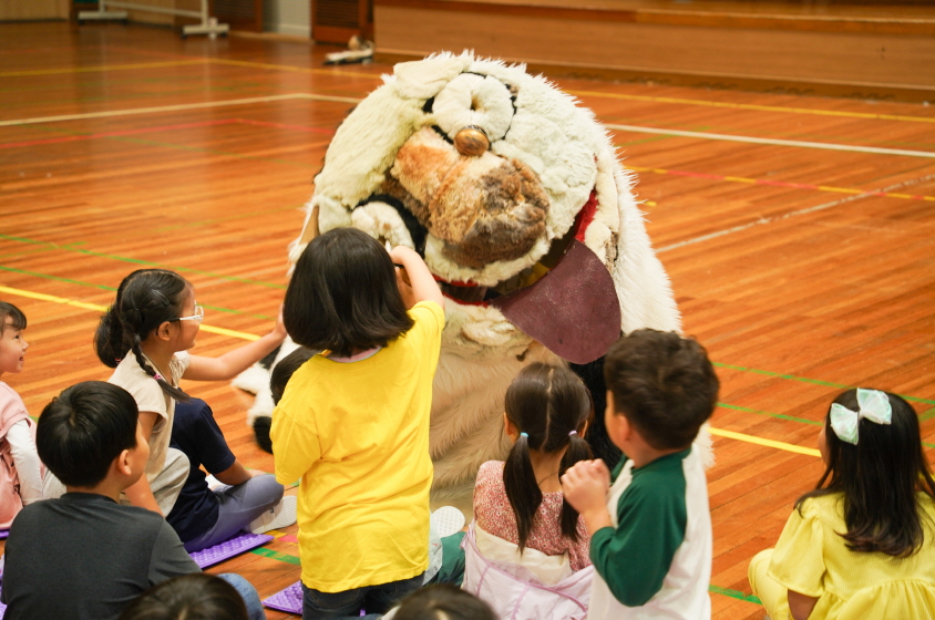 풍물마당놀이 해피 공연에서 아이들이 사자탈 속 해피를 쓰다듬으며 교감하는 장면｜조치원 대동병설유치원 전통공연
