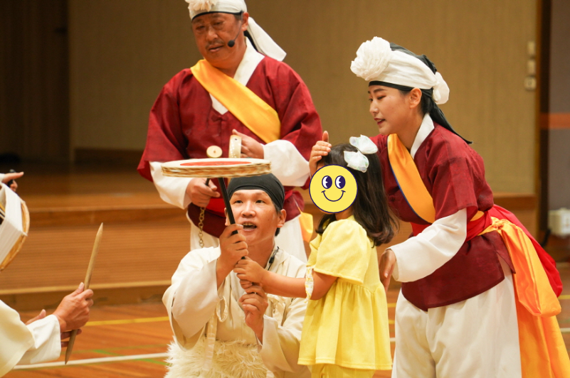 풍물마당놀이 해피 공연 중 유치원 어린이가 출연자와 함께 버나놀이(접시돌리기)를 체험하는 장면｜조치원 대동병설유치원 전통공연