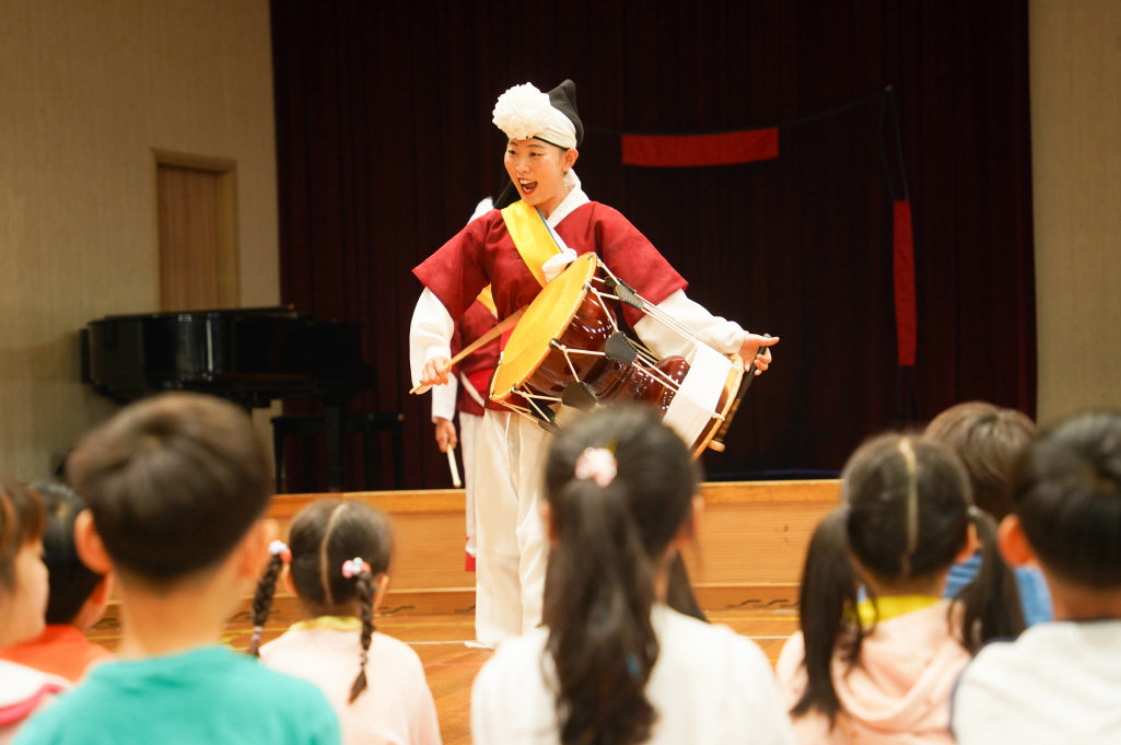 풍물마당놀이 해피 공연 중 장구 연주자가 아이들과 눈을 마주치며 신나게 장단을 맞추는 모습｜조치원 대동병설유치원 유치원 전통공연