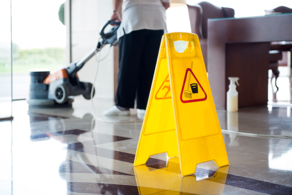 미끄럼주의 표지판과 청소도구가 놓여 있음