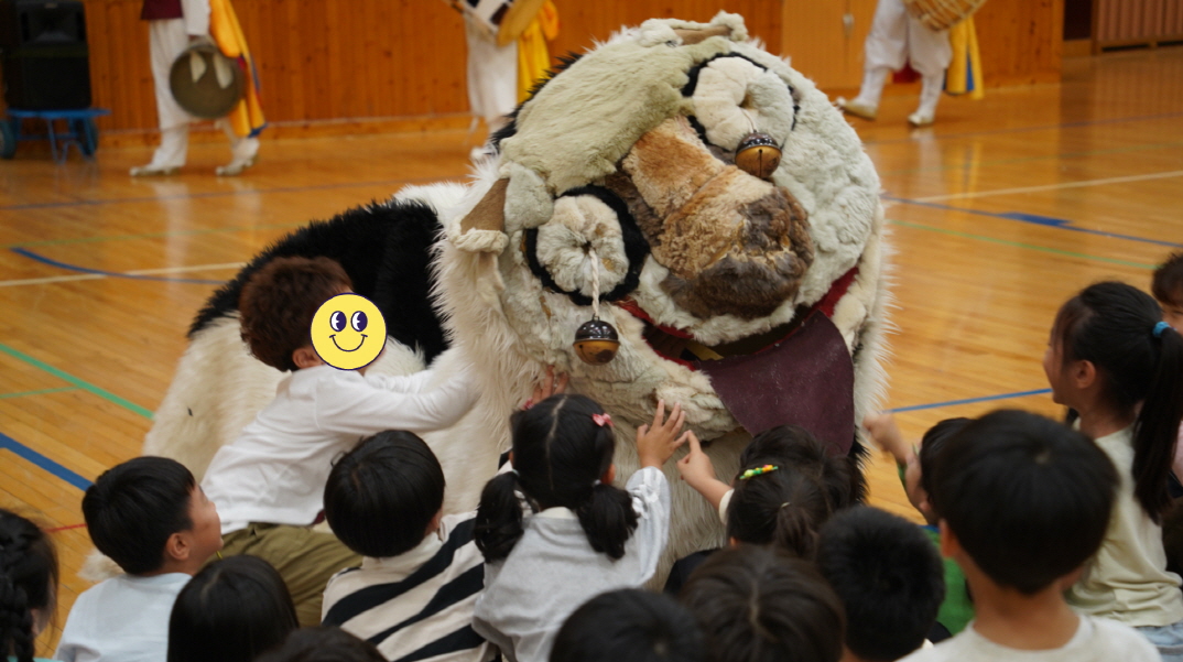 풍물마당놀이 해피 공연에서 아이들이 강아지탈 해피를 반가워하며 손을 뻗는 모습