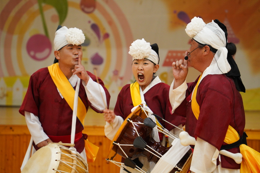 풍물마당놀이 해피 공연에서 장구와 북을 연주하며 표정으로 장난을 주고받는 출연자들의 즐거운 모습