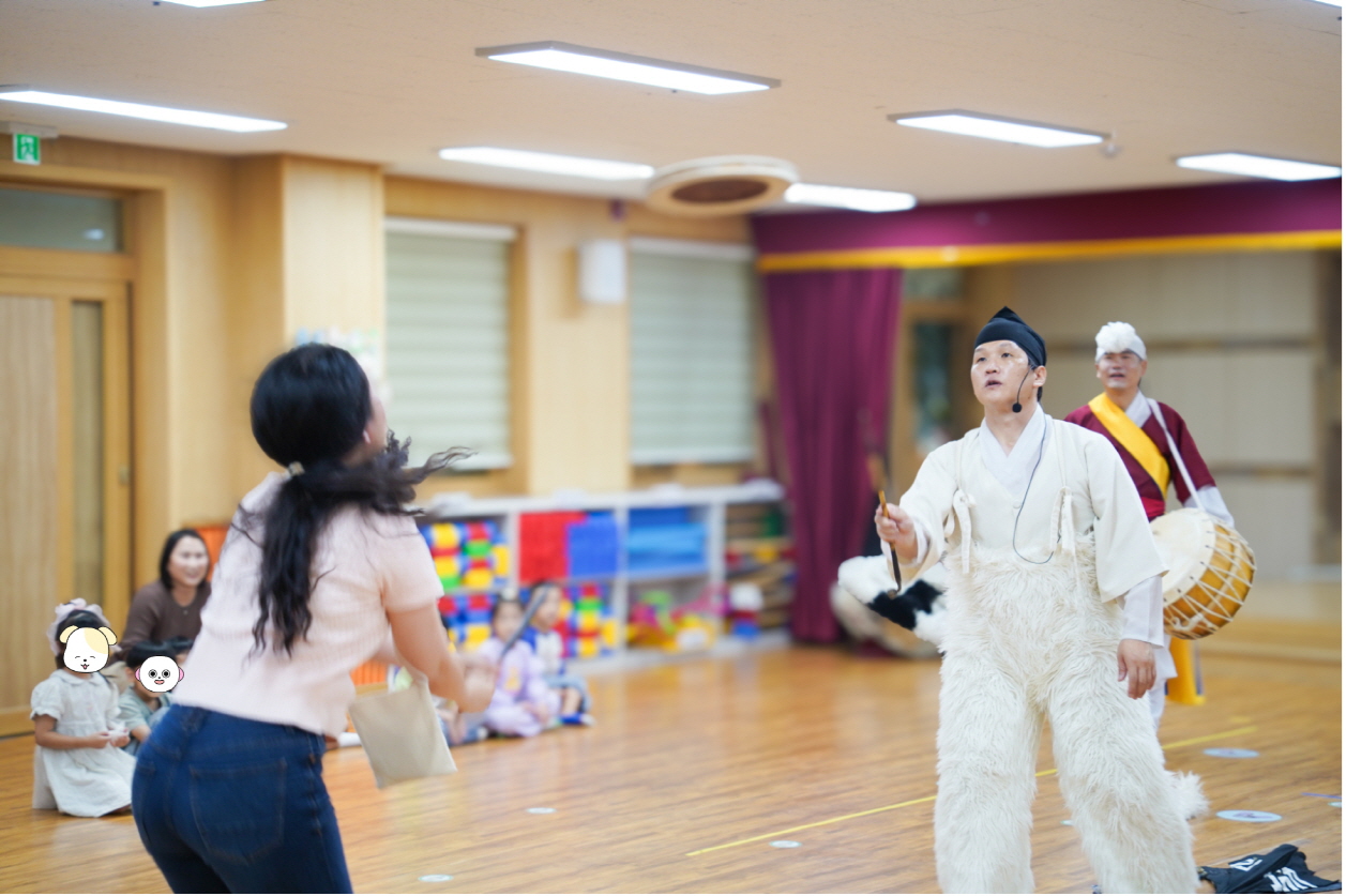 대전 산내유치원 풍물마당놀이 해피 공연에서 선생님이 연희자와 함께 버나를 받아보며 참여하는 체험 장면