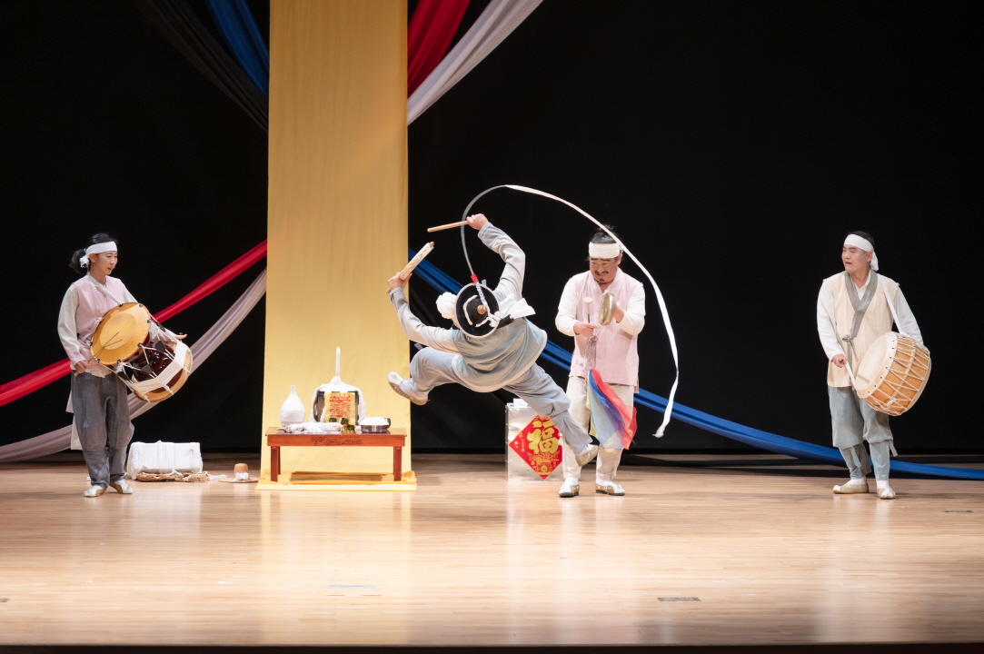 한국 전통 연희 공연 ‘복이 팡팡’에서 상모를 돌리며 공중에서 몸을 비트는 역동적인 춤 동작을 펼치는 연희꾼과 장구·북 장단을 맞추는 출연자들