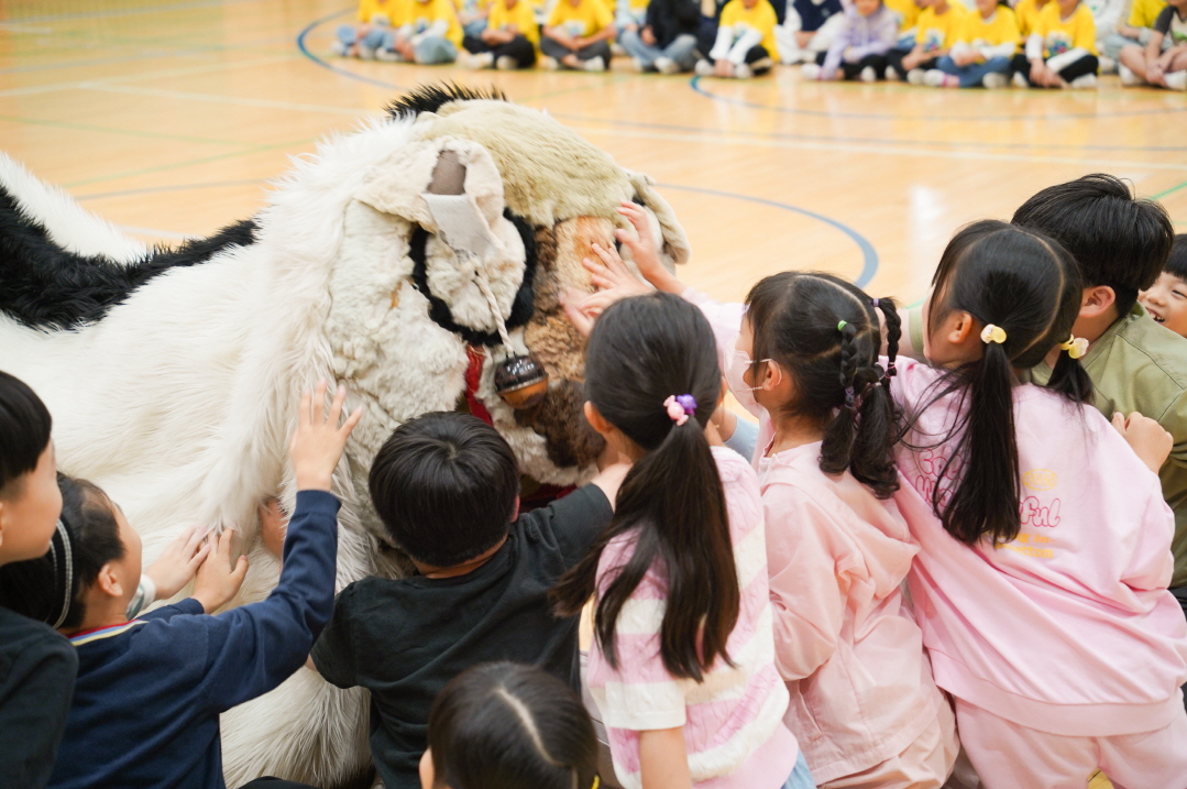 풍물마당놀이 해피 공연에서 아이들이 커다란 강아지 해피를 만지며 즐겁게 교감하는 모습