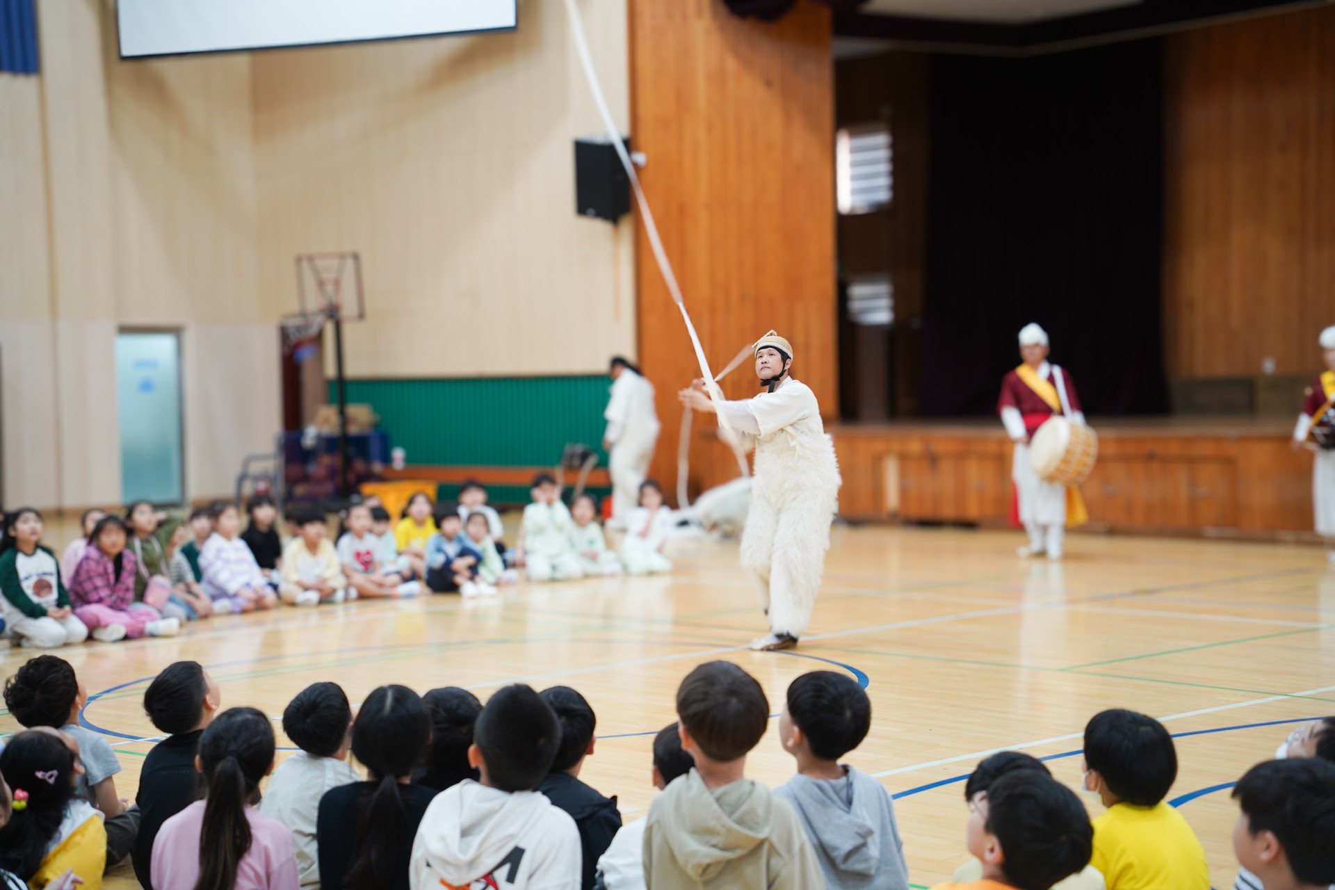 풍물마당놀이 해피 공연에서 연희자의 열두발 상모  퍼포먼스를 유치원 아이들이 집중해 지켜보는 모습