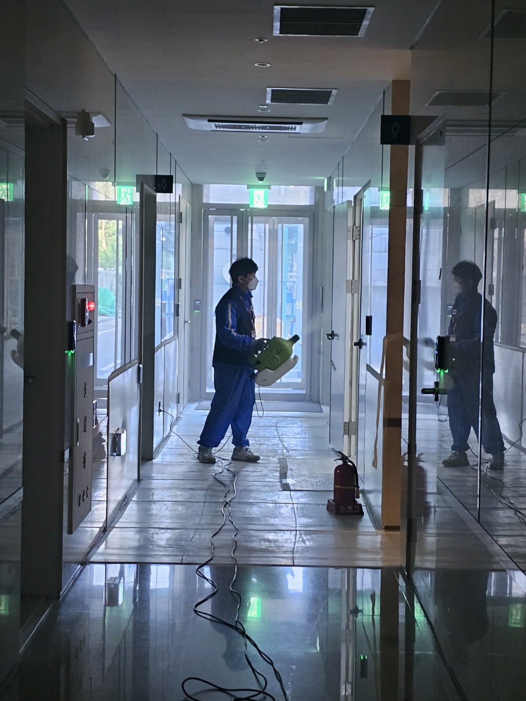 회사 건물 내부를 소독하는 작업자