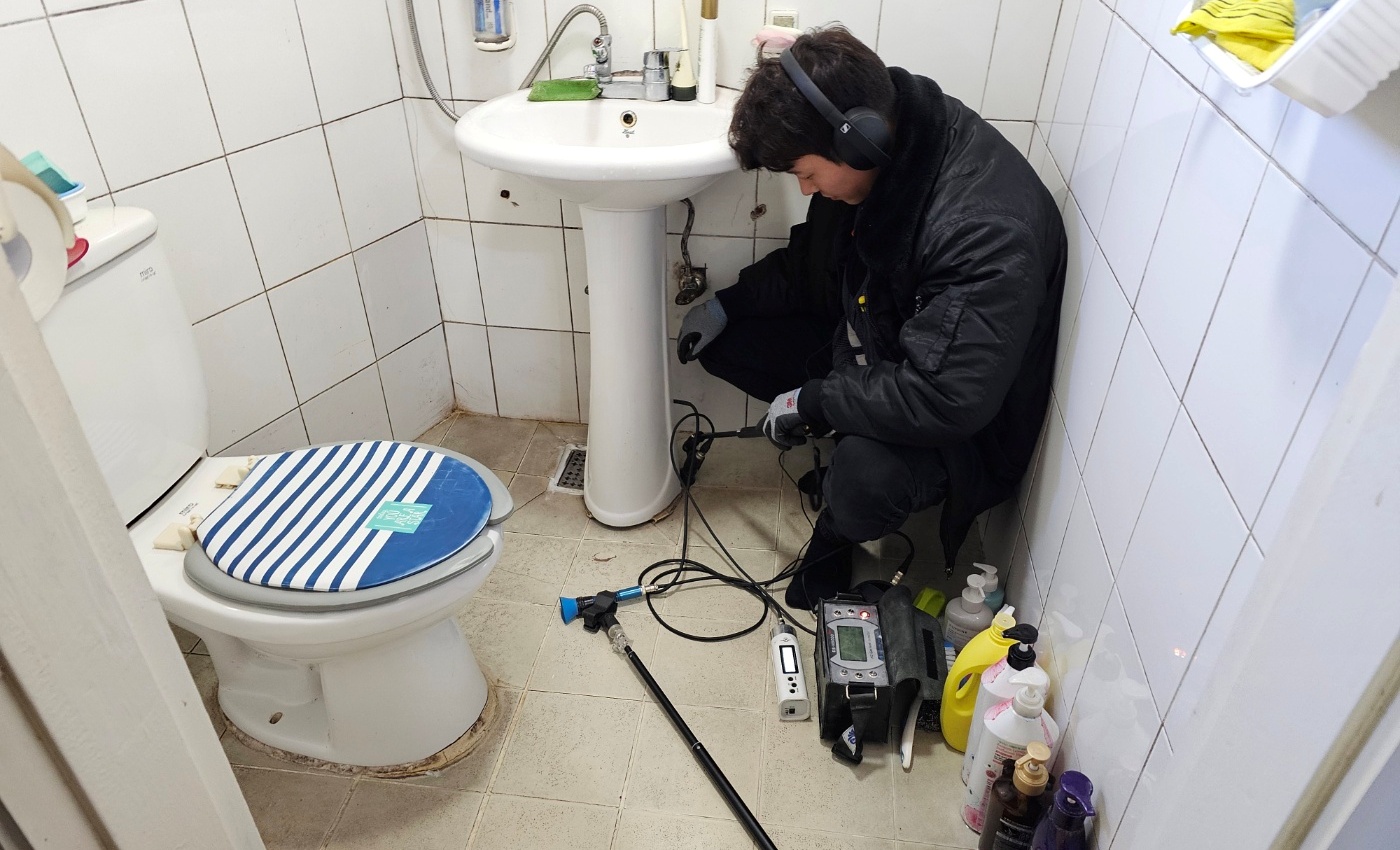 의정부 한 다세대 주택 화장실에서 청음식 누수탐지기로 세면대 배관을 검사하는 모습