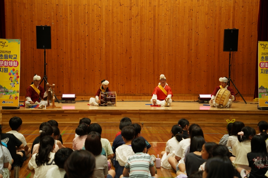 초등학생 앞에서 사물놀이 네 가지 악기를 연주하는 전통연희자들의 시연 공연 장면